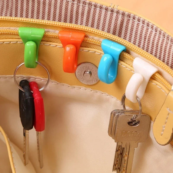 A yellow bag features a row of colorful key holder clips and a metal key attached to the strap.
