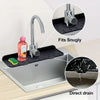 Silicone faucet splash guard mat fitting snugly on a kitchen sink with a direct drain feature.