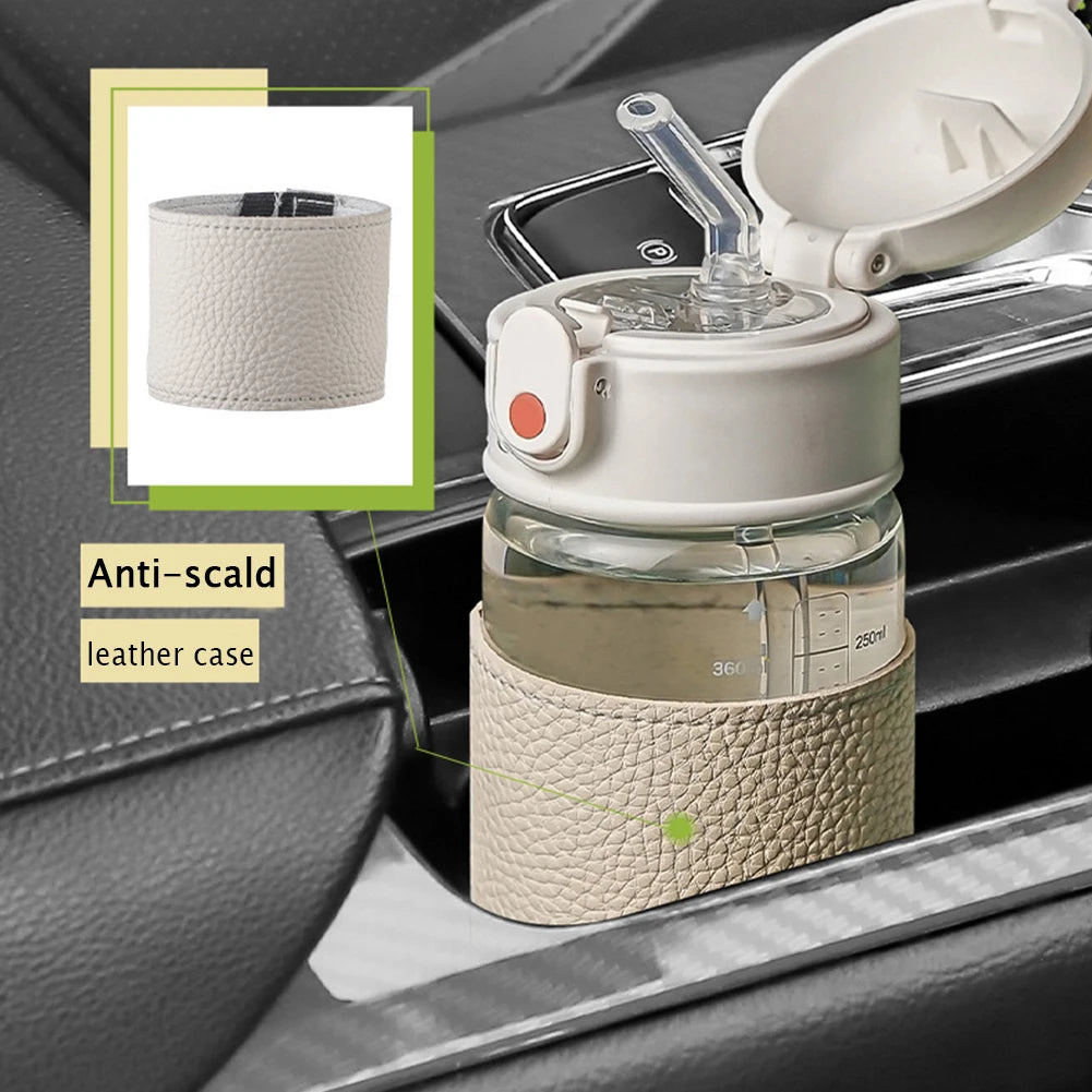 Une tasse à paille en acier inoxydable portable avec une housse en cuir est placée dans un porte-gobelet de voiture.