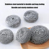 A pile of durable and sturdy grey stainless steel scrubber pads on a wooden surface.