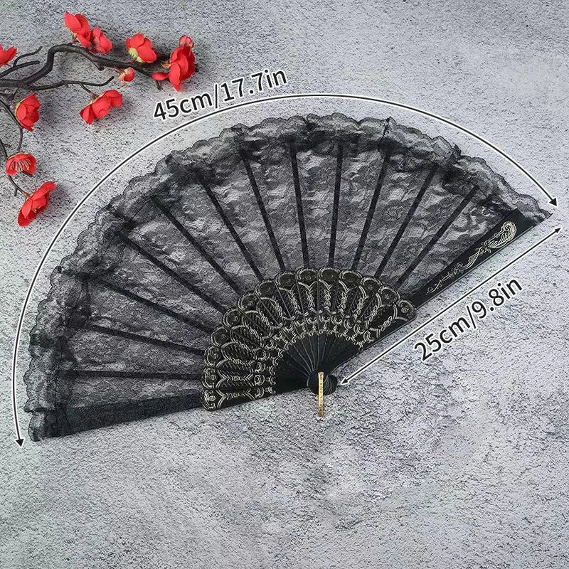 Black lace fabric folding hand fan with red flower accents shown against a gray background.