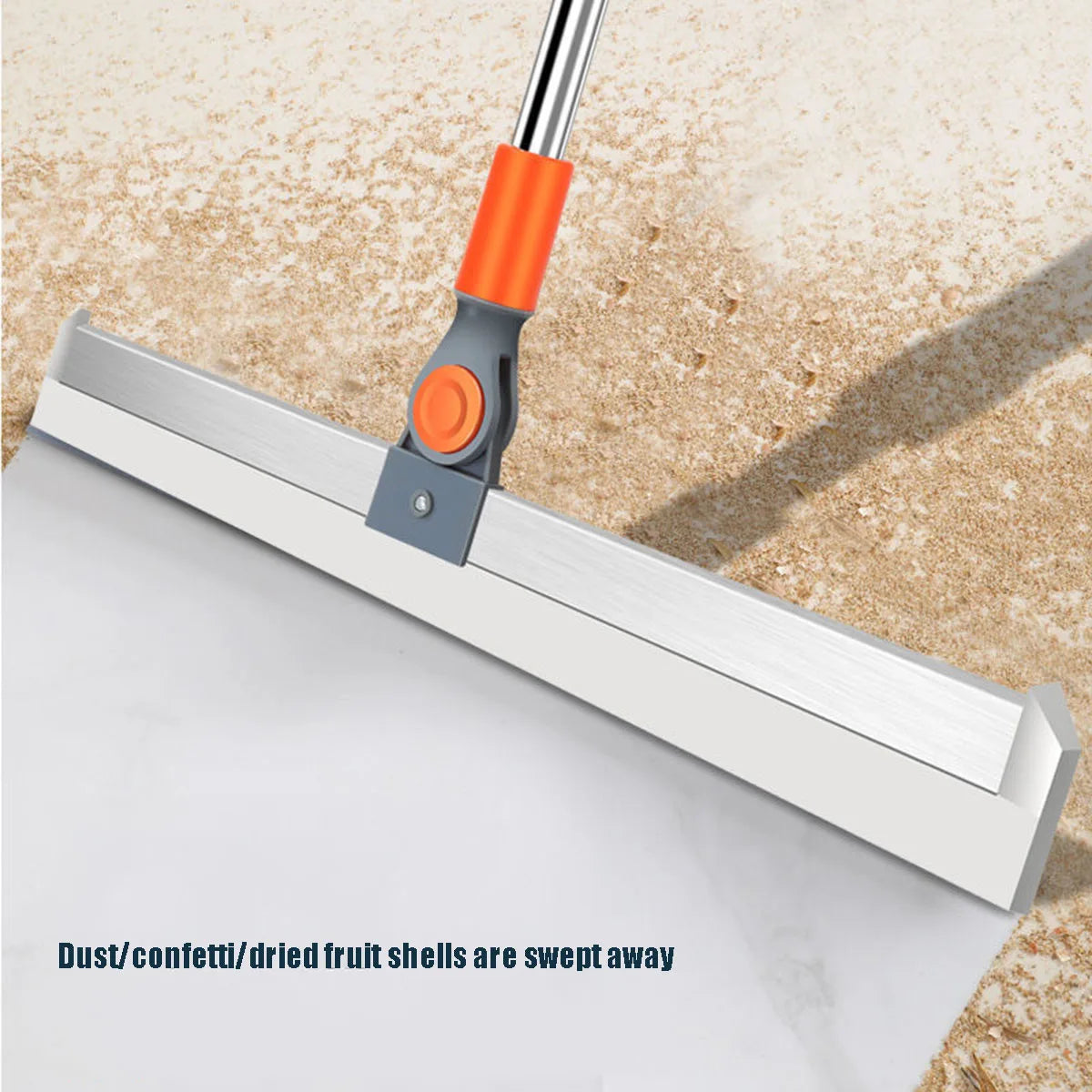 A silicone squeegee broom with an aluminum handle is shown sweeping dust and fruit shells away from a white surface.