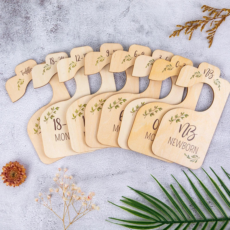 A set of natural bamboo closet dividers with engraved numbers and leaves arranged on a light gray surface.