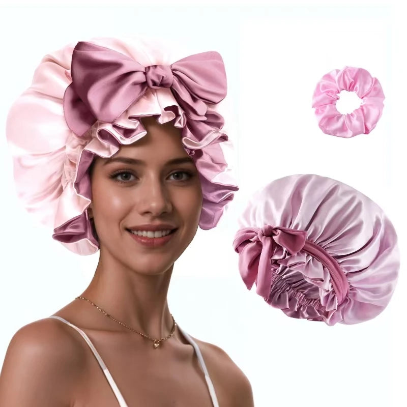 A woman models a pink satin silk hair bonnet with matching accessories.