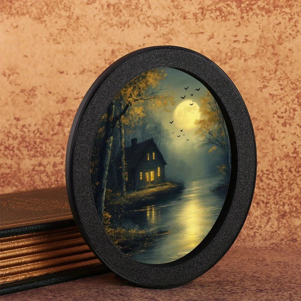 A round, dark frame holds a painting of a moonlit landscape with trees and a house.