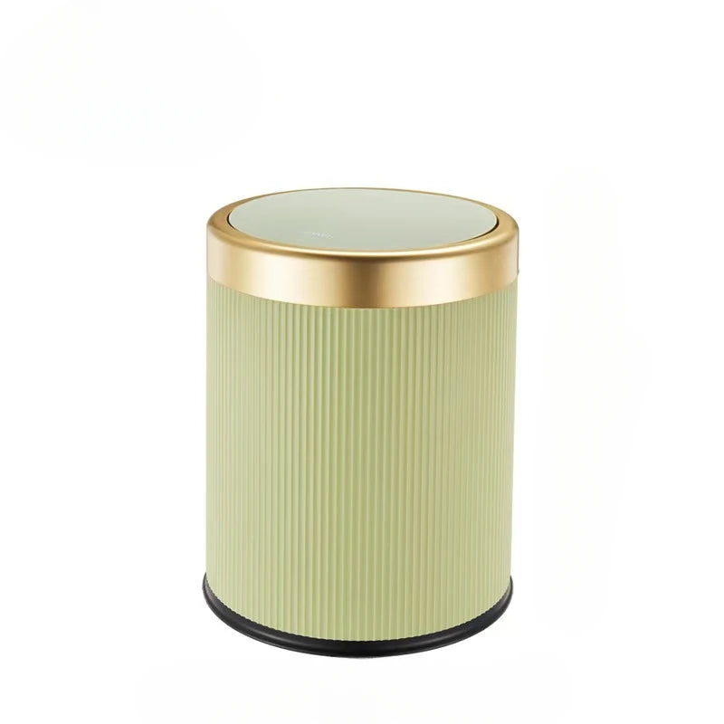 A cylindrical trash can with a light green ribbed body and a gold rim and lid.