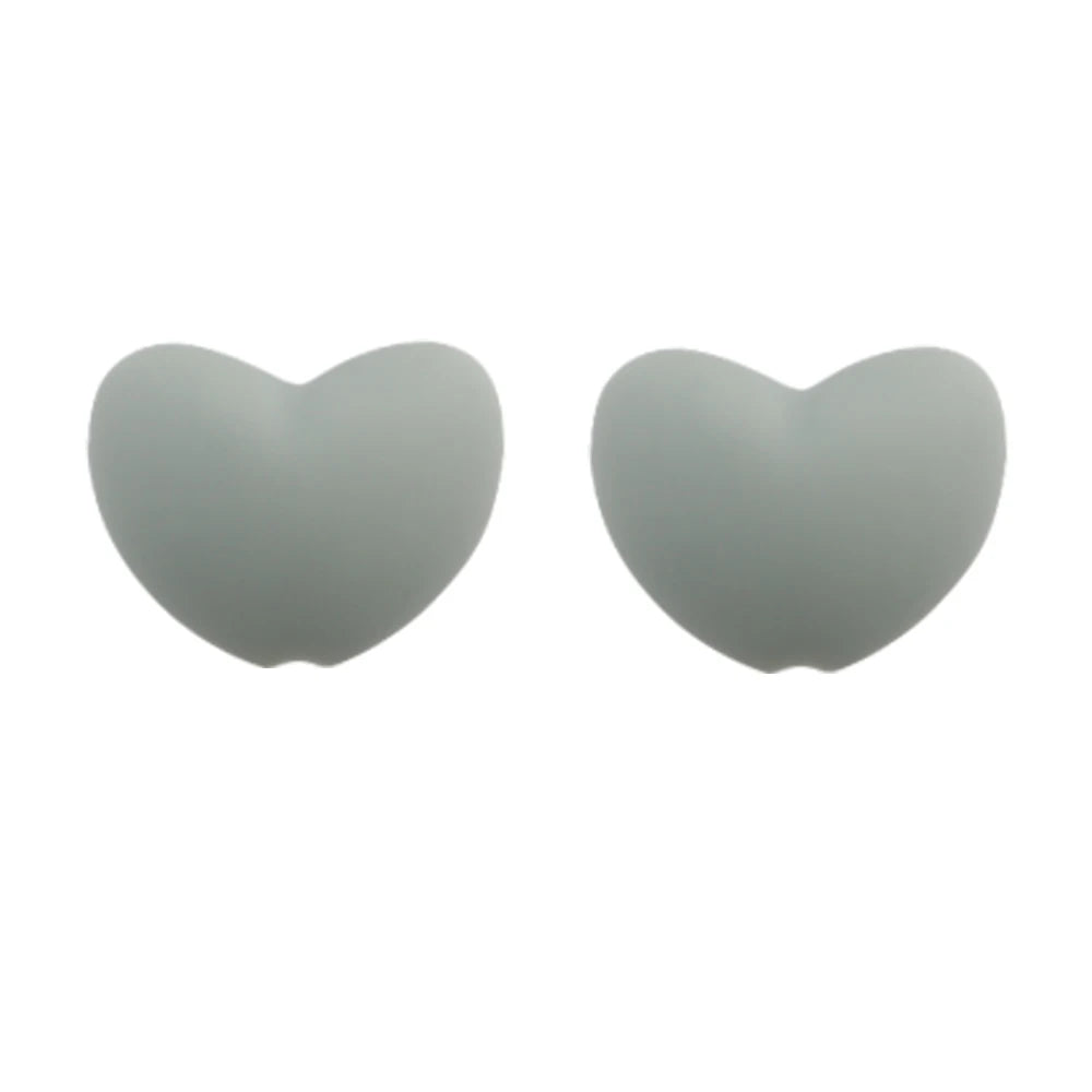 A pair of smooth, heart-shaped silicone charm beads in a light gray color.
