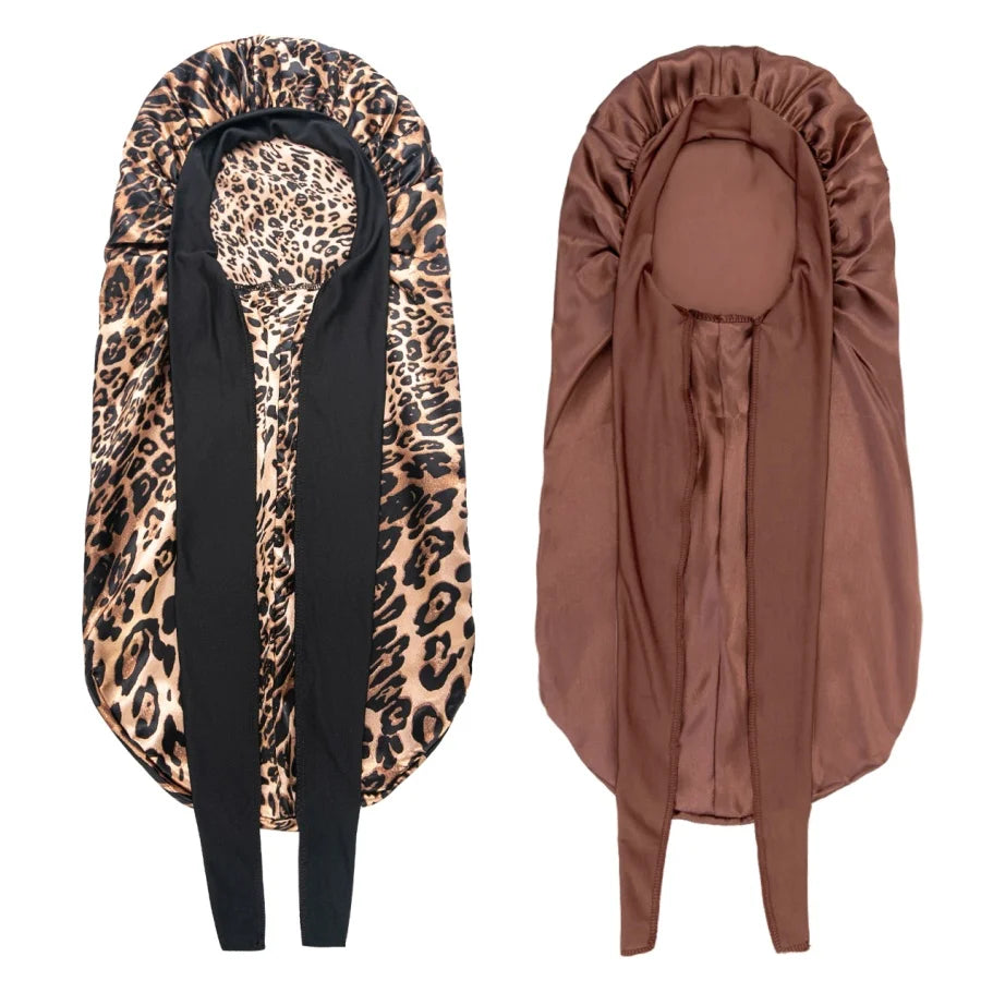 A satin sleep bonnet in brown and black leopard print fabric is shown folded.