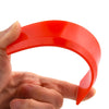 A hand holds a bright red silicone scraper used for grout and gap filling.