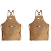 A tan canvas apron with utility pockets and crossed straps is shown against a white background.