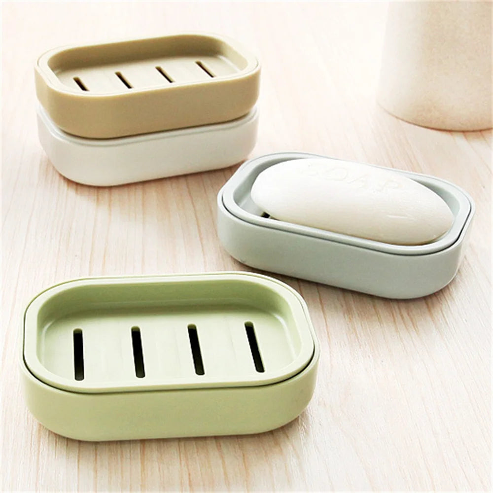 A set of double layer drain soap dishes in light green and off-white colors.