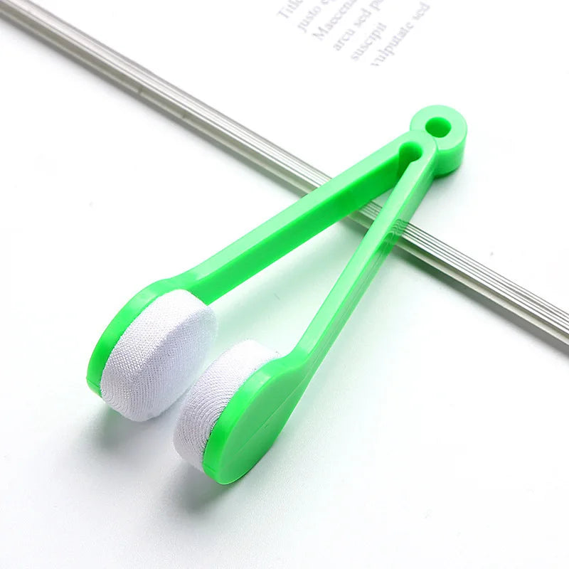 A green multifunctional eyeglass cleaning kit with a brush is shown on a white background.