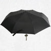 A black folding katana sword umbrella is shown open against a white background.