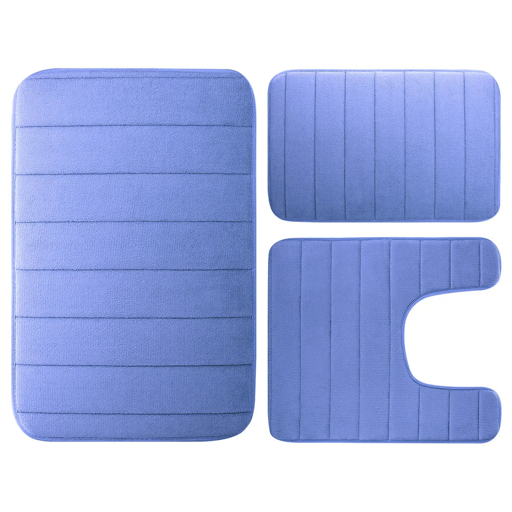 A set of three purple memory foam bathroom rugs, including a rectangular mat and two curved mats.