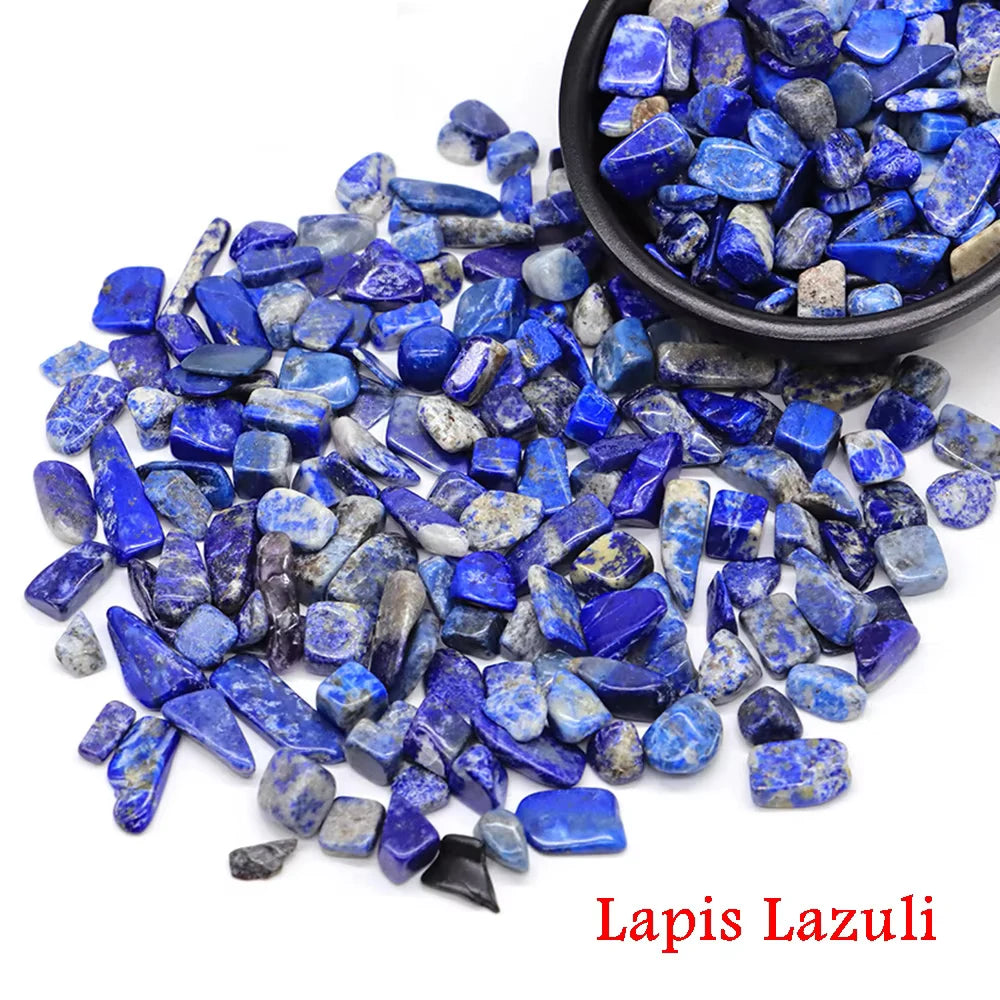 Una pila de vibrantes cristales de lapislázuli azul esparcidos sobre un fondo blanco con un tazón pequeño cerca.