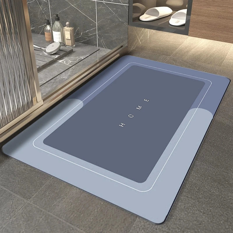 A rectangular gray bath mat with the word HOME embossed on it, placed on a tiled floor next to a bathroom vanity.