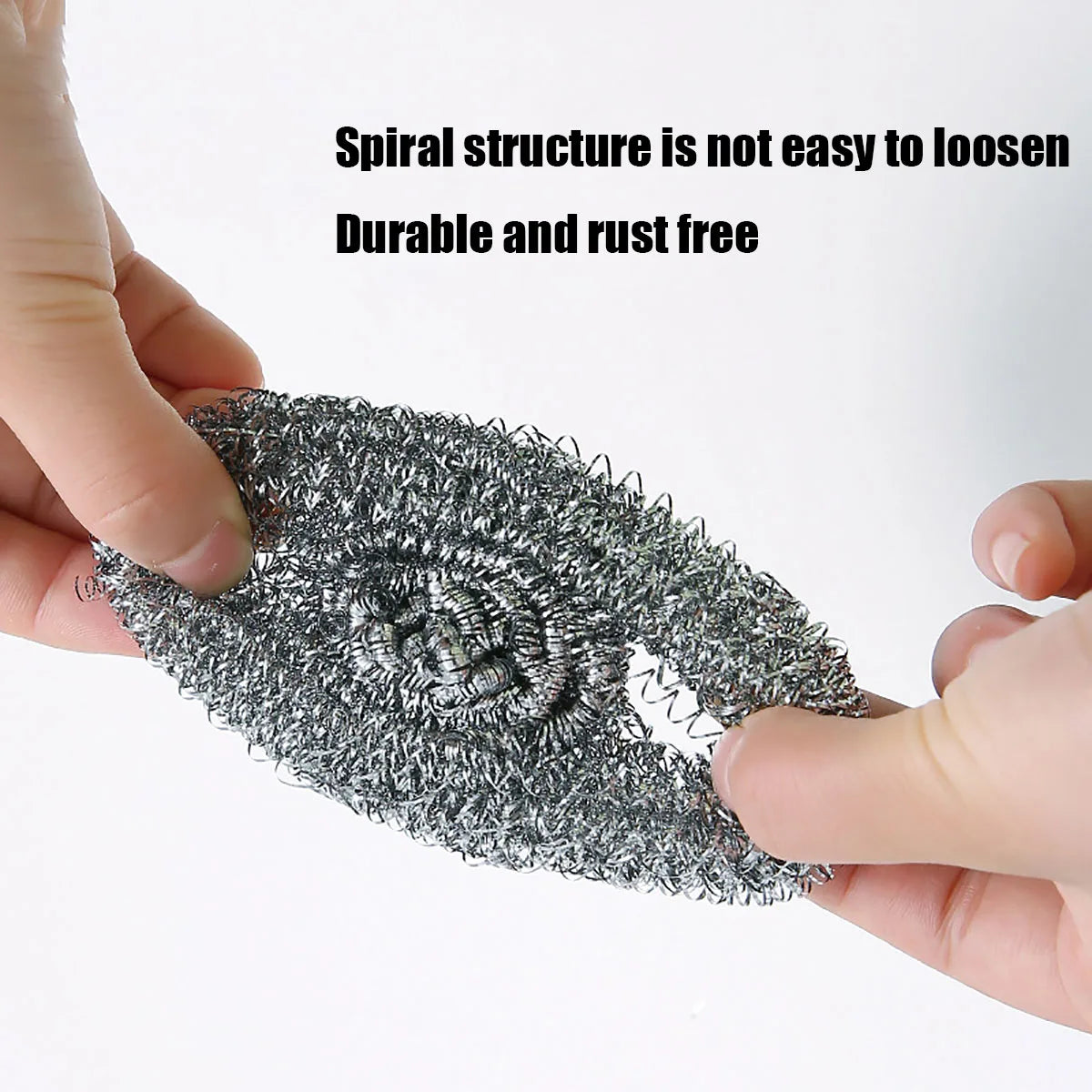 A hand is holding a black spiral structure scrubber pad, demonstrating its durable and rust-free nature.