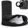 A black reusable shoe laundry bag containing a white athletic shoe, next to a washing machine accessory.