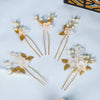 A set of pearl flower bridal hair clips featuring delicate white and gold floral designs on thin gold wires.