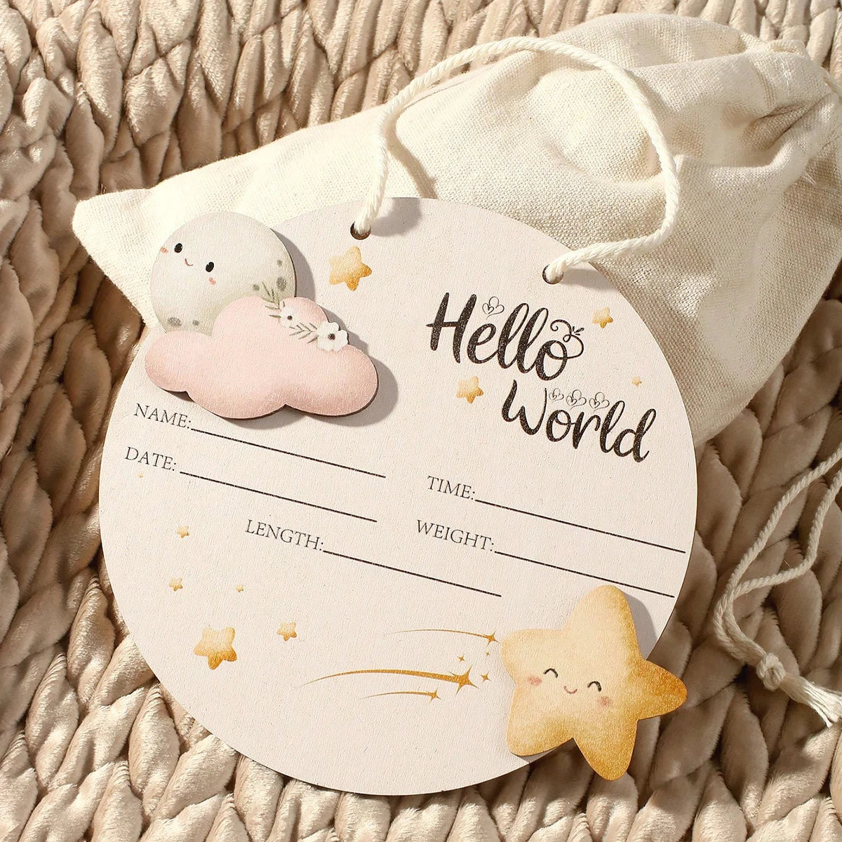 Bolsa de tela beige con etiqueta circular de nube blanca y estrella amarilla, usada como utilería para fotos de recién nacido