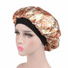 A woman wearing a satin sleep bonnet with a floral pattern and a black elastic band.
