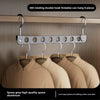 A silver aluminum double hook foldable storage rack with eight hangers hanging on a wooden rod.