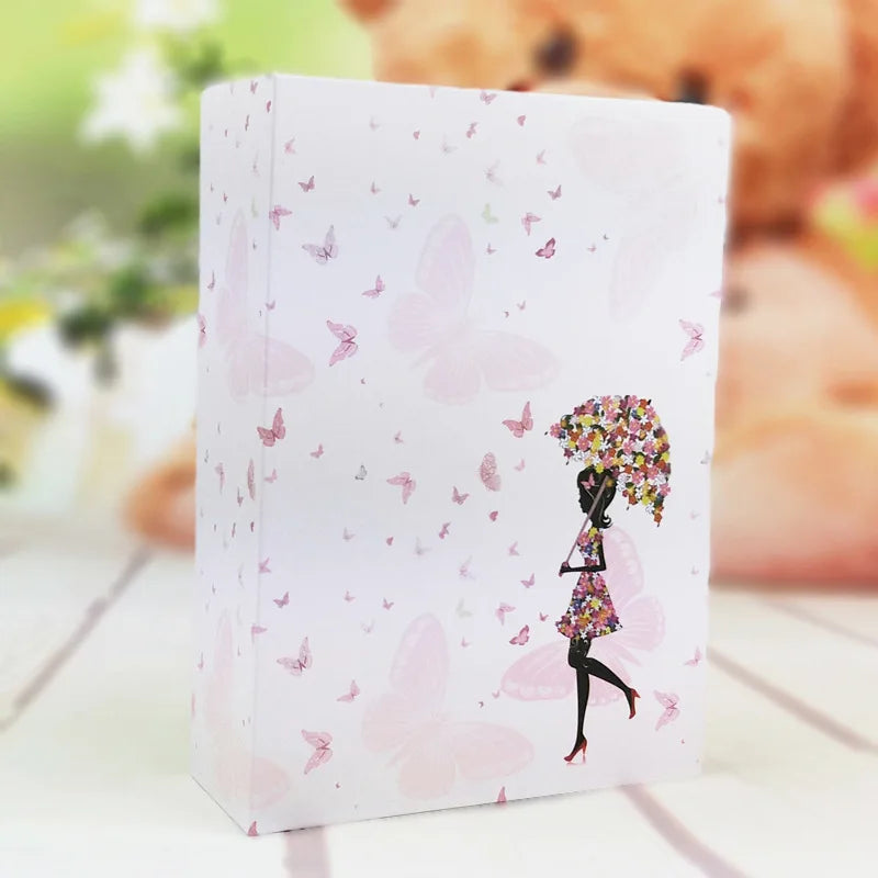 Álbum de fotos blanco con diseño de mariposa rosa y silueta de una persona sosteniendo un ramo de flores.