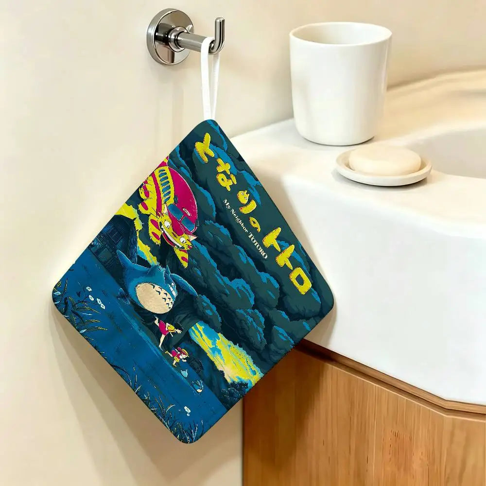 A dark blue fabric towel featuring a Totoro cartoon character hanging on a wall.