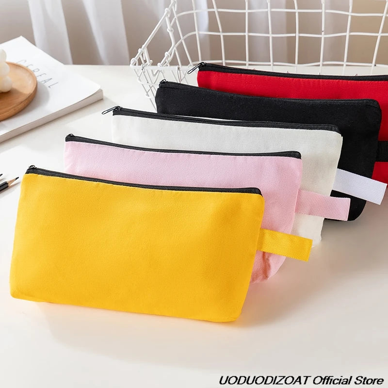 A collection of colorful zipper bags in yellow, pink, white, and black are displayed on a white surface.