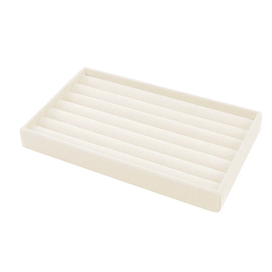 A rectangular velvet jewelry organizer tray with a slotted design.