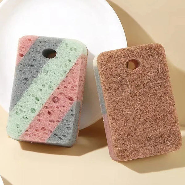 A set of two double-sided cleaning sponges, one gray and green striped, and one brown, resting on a light surface.