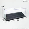 A clear dustproof display case with a black base and a slotted interior, shown from above.