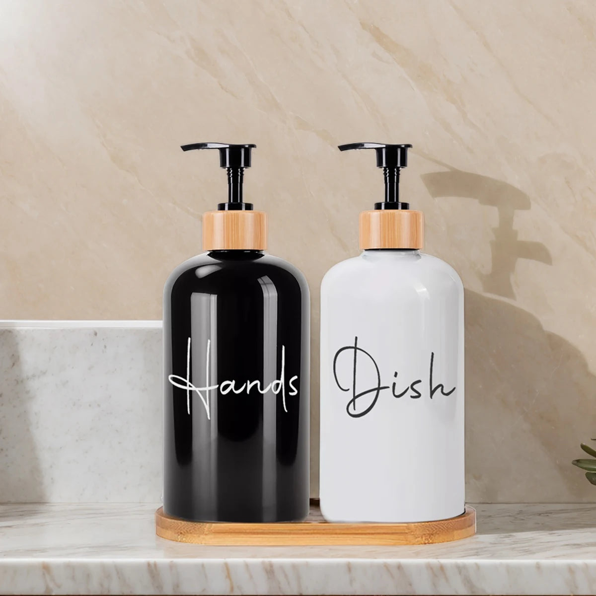 Two large capacity refillable hand soap dispenser bottles, one black and one white, sitting on a wooden tray.