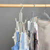 A collection of multi-layer storage hangers in various colors and textures hanging from a wooden rod.