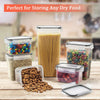 A set of five clear plastic food storage containers with lids filled with various dry foods like pasta nuts and grains