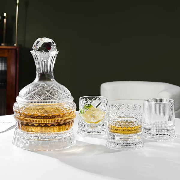 A crystal decanter set featuring a glass bottle, various sized glasses, and a coaster on a white table.