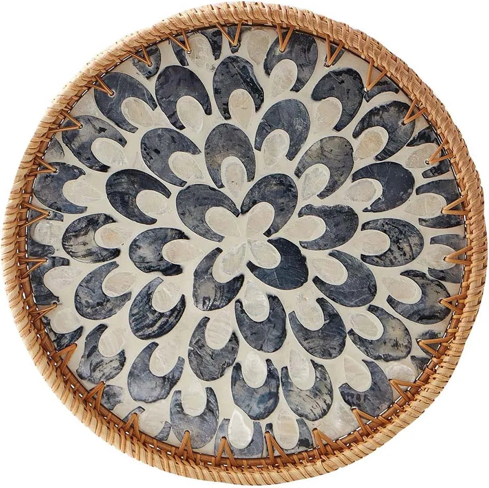 Round rattan serving tray with mother of pearl inlay featuring a geometric pattern.