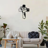 Black metal cross wall art decor hanging on a white wall above a light-colored sofa.