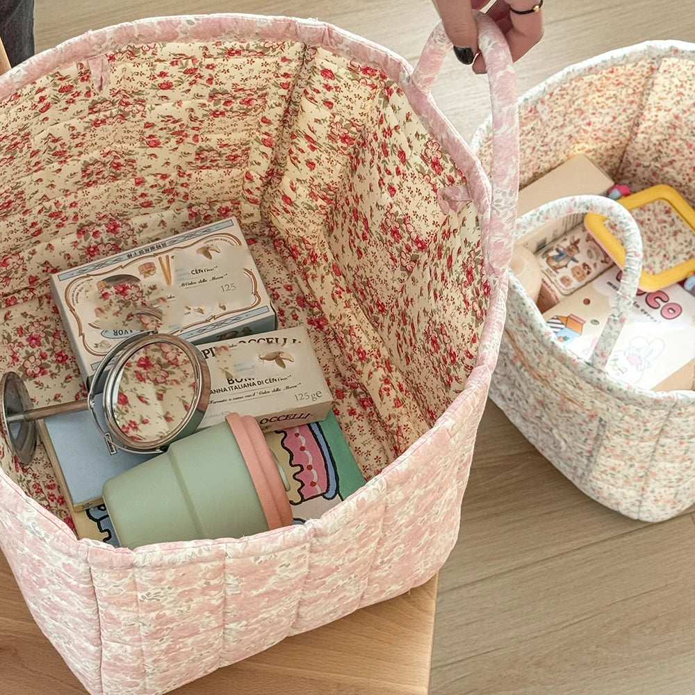 A pink floral storage basket with a handle is shown, filled with various small items and jars.