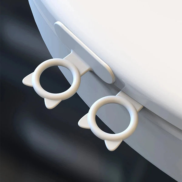 Close-up of silicone self-adhesive cabinet door handle lifters attached to a white cabinet surface.