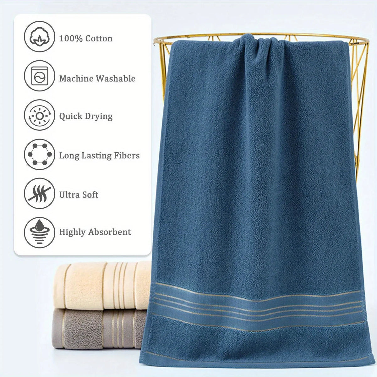 A dark blue ultra-absorbent pure cotton bath towel hanging next to rolled towels and features washing and drying icons.
