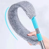 A hand holds a telescopic long handle microfiber duster with a gray, fuzzy head.