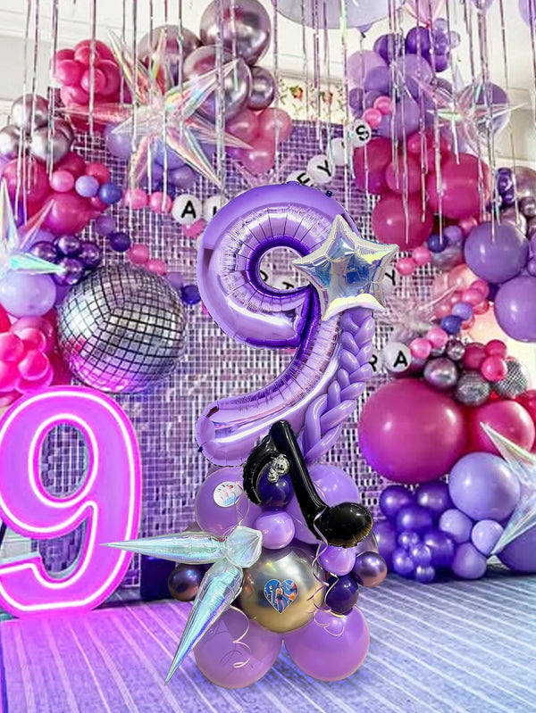 A vibrant balloon pillar set featuring purple and pink balloons, including large number balloons and star accents.