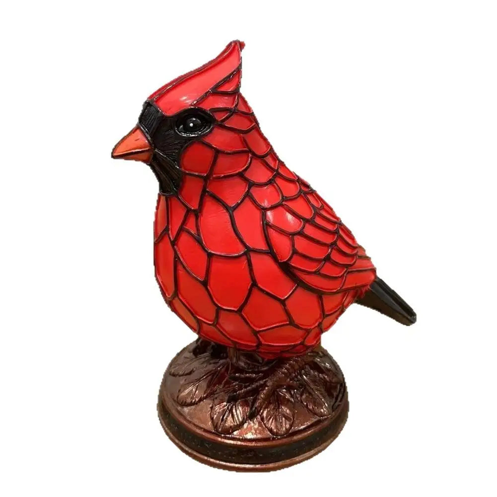 A decorative resin bird sculpture of a red bird with black details standing on a brown base.