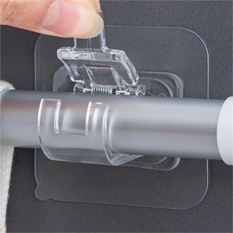 A hand is installing a clear plastic hook set onto a gray adhesive panel for a curtain rod.