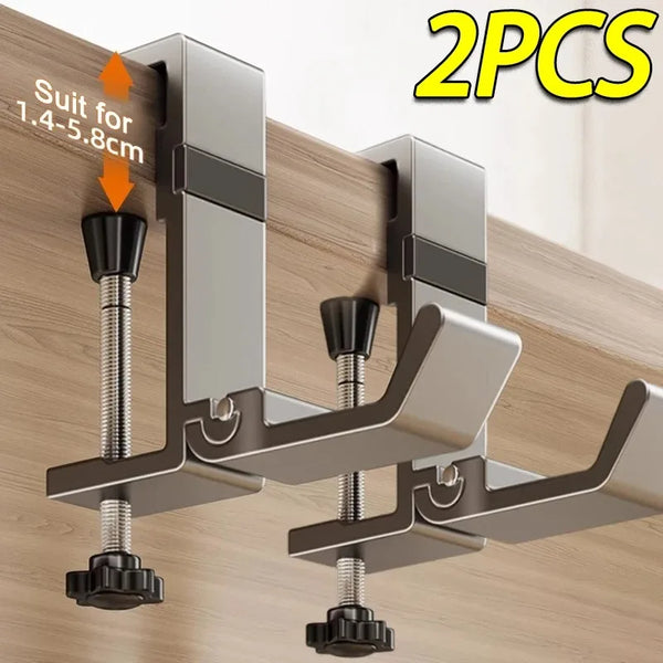 Two silver adjustable desk hooks for hanging items on a wooden surface