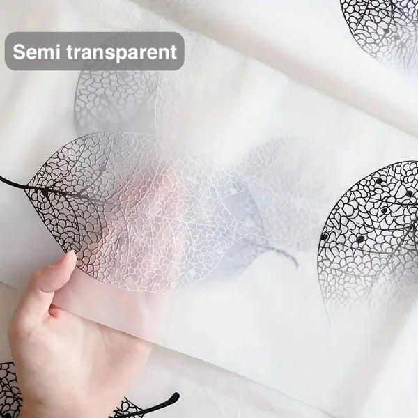 Eine Hand hält eine halbtransparente Kunststoff-Blatt-Duschvorhang-Ainsatz mit komplizierten Mustern auf weißem Hintergrund.