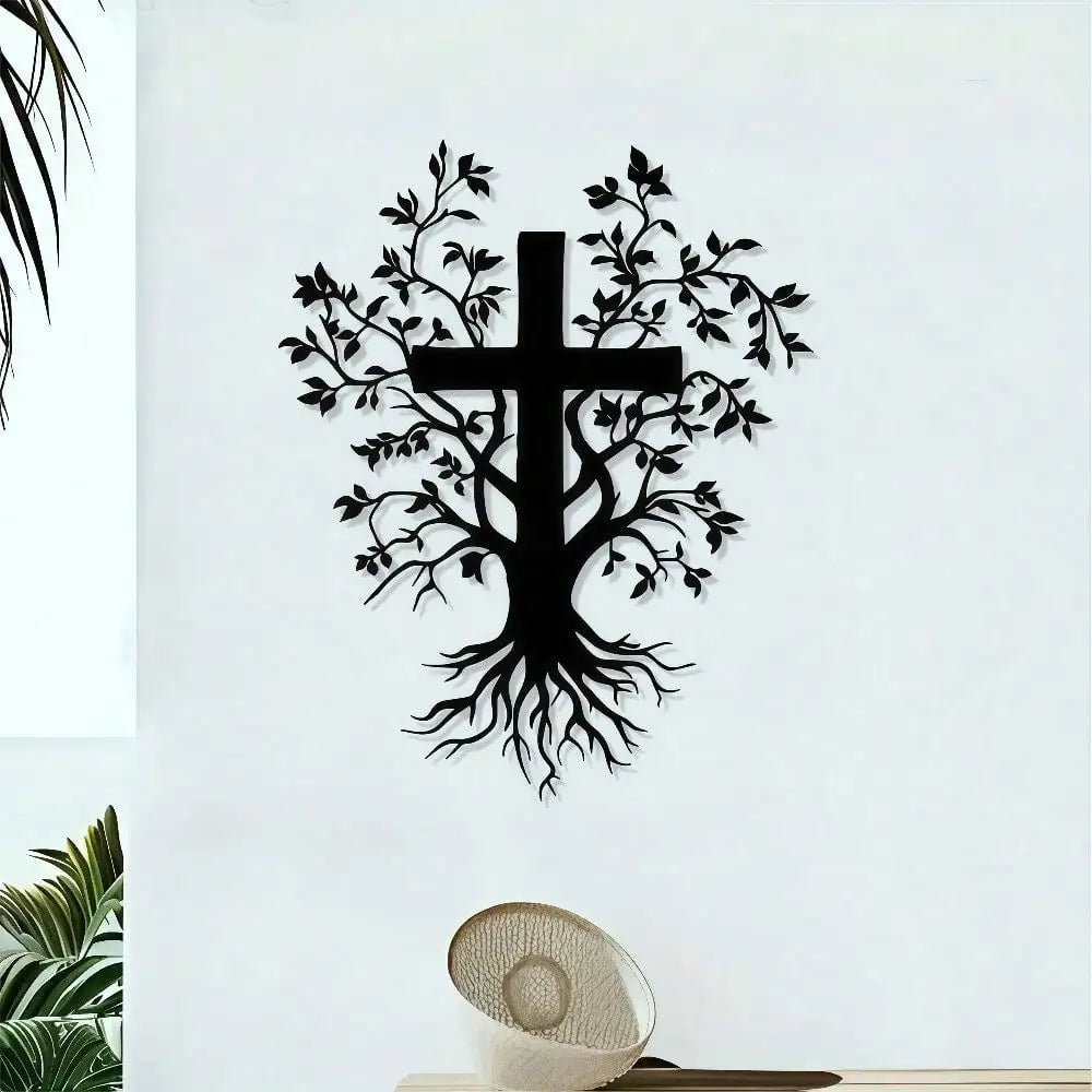 Black silhouette wall art featuring a cross with intricate tree roots and leaves on a white wall.