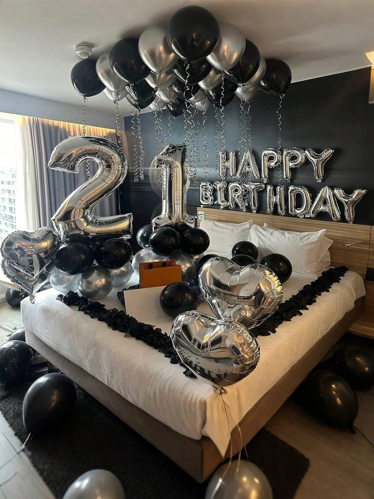 Silver and black balloons spelling out Happy Birthday with a number 2 and 1 decoration