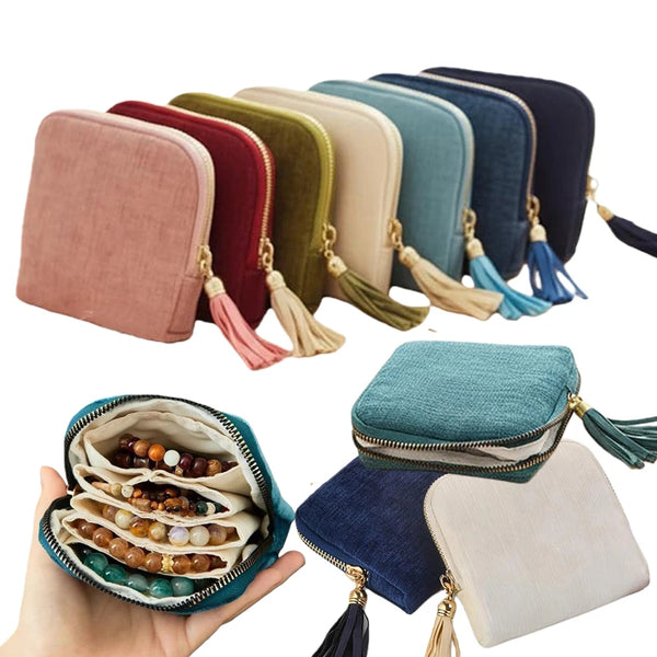 A collection of velvet jewelry storage pouches in various shades of pink, green, blue, and gray with tassels.